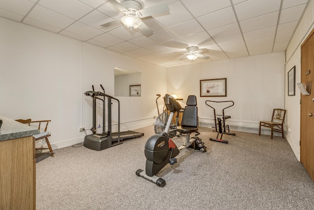 workout area with a ceiling fan, a drop ceiling, carpet floors, and baseboards