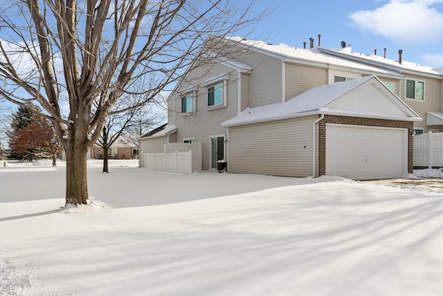 view of snowy exterior with a garage