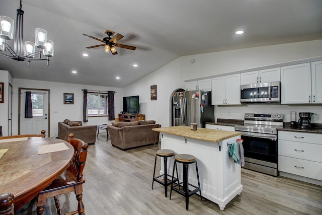 kitchen with white cabinetry, lofted ceiling, decorative light fixtures, ceiling fan with notable chandelier, and appliances with stainless steel finishes