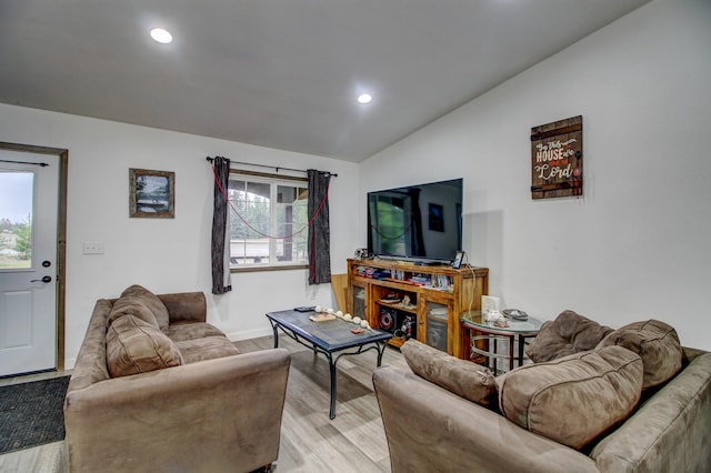 living room with vaulted ceiling and light wood-type flooring