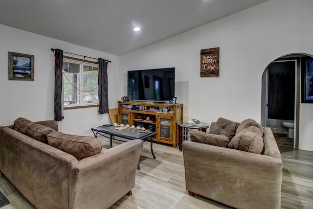 living room with light wood-type flooring and vaulted ceiling