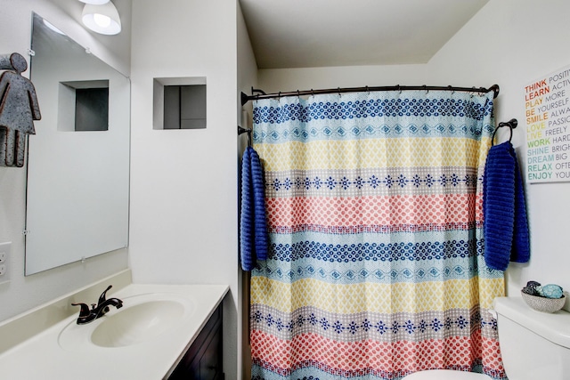 bathroom with vanity, curtained shower, and toilet