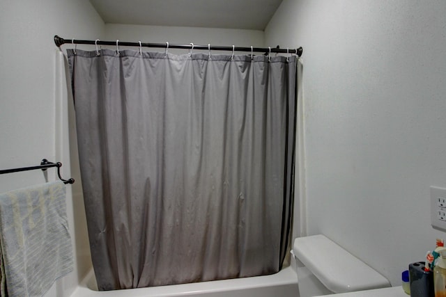 bathroom featuring shower / bath combination with curtain and toilet