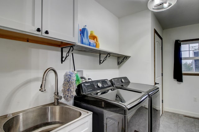 washroom featuring washing machine and clothes dryer, sink, and cabinets