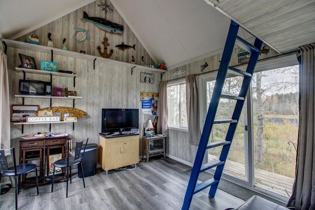 interior space featuring hardwood / wood-style flooring, wooden walls, and vaulted ceiling