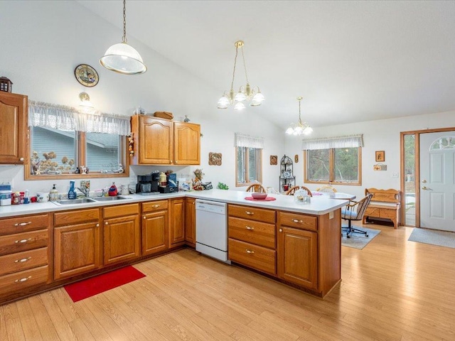 kitchen featuring kitchen peninsula, sink, pendant lighting, an inviting chandelier, and dishwasher