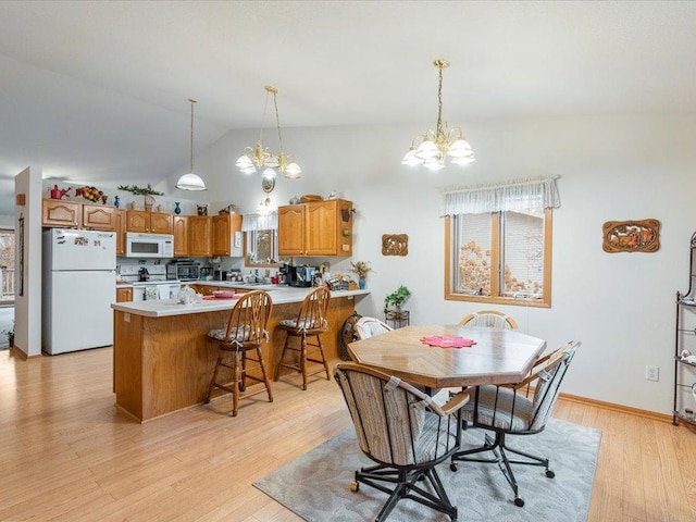 dining area with a chandelier, light hardwood / wood-style floors, and lofted ceiling