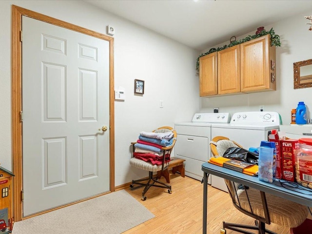 laundry room with washer and clothes dryer, cabinets, and light hardwood / wood-style flooring