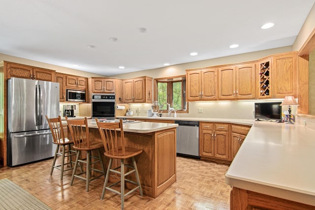 6678 Hemlock Ln N, Maple Grove, MN 55369 - kitchen with appliances with stainless steel finishes, a breakfast bar, light countertops, a center island, and backsplash