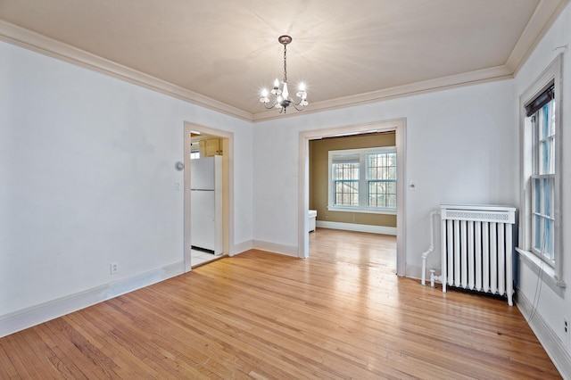 empty room with crown molding, radiator heating unit, a chandelier, and light wood-type flooring