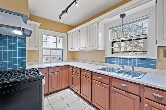 kitchen with black stove, sink, tasteful backsplash, light tile patterned floors, and exhaust hood