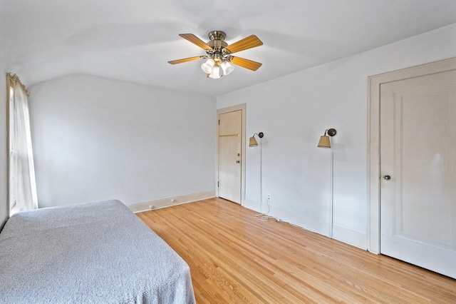 bedroom featuring ceiling fan, wood-type flooring, and vaulted ceiling