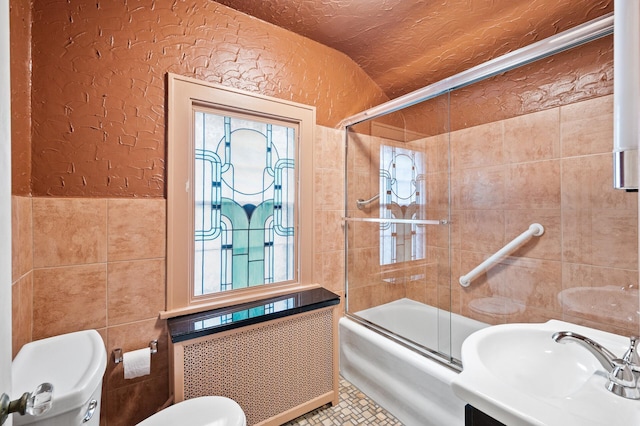 full bathroom featuring radiator heating unit, enclosed tub / shower combo, a wealth of natural light, and sink