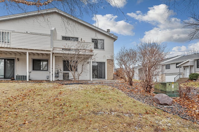 back of house featuring central AC and a yard