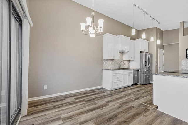 kitchen featuring white cabinetry, pendant lighting, track lighting, and appliances with stainless steel finishes