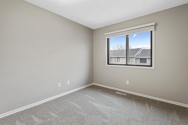 carpeted spare room with a textured ceiling