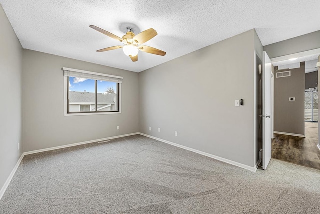 spare room featuring ceiling fan, carpet floors, and a textured ceiling