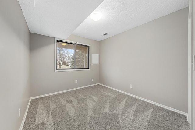 carpeted spare room featuring a textured ceiling