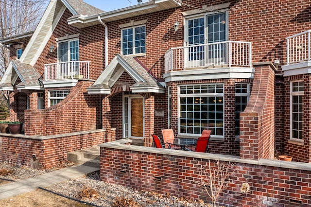 multi unit property with brick siding and a balcony