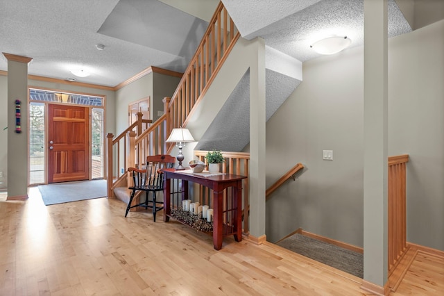 entryway with baseboards, a textured ceiling, and wood finished floors