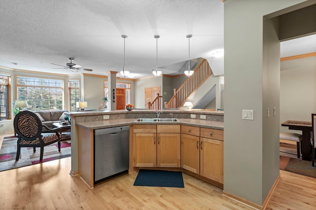kitchen with stainless steel dishwasher, pendant lighting, light wood-style floors, open floor plan, and a sink