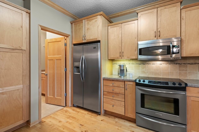 kitchen with crown molding, light wood-style flooring, light brown cabinetry, and stainless steel appliances