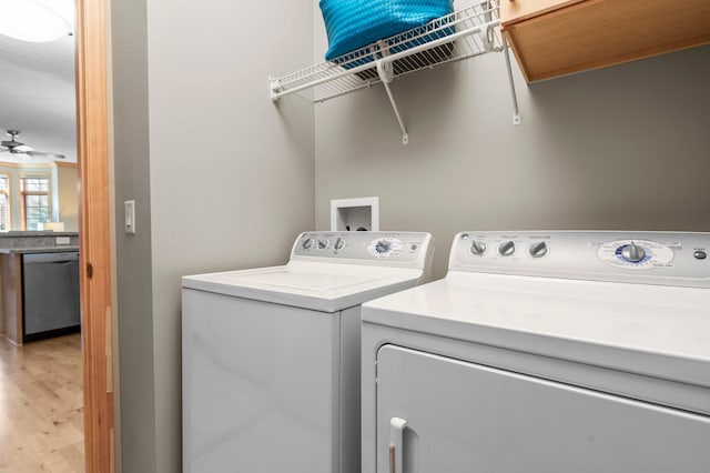 laundry area featuring laundry area, a ceiling fan, light wood-style flooring, and washer and clothes dryer