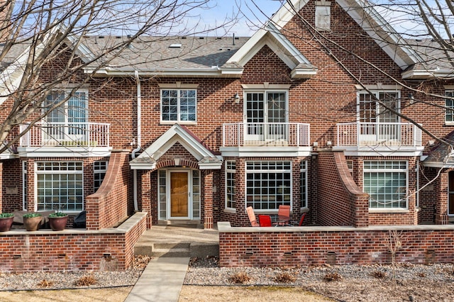 view of front of property featuring brick siding and a balcony