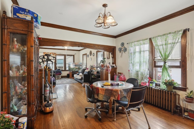 3532 Longfellow Ave, Minneapolis, MN 55407 - dining room featuring radiator heating unit, wood finished floors, crown molding, and a chandelier