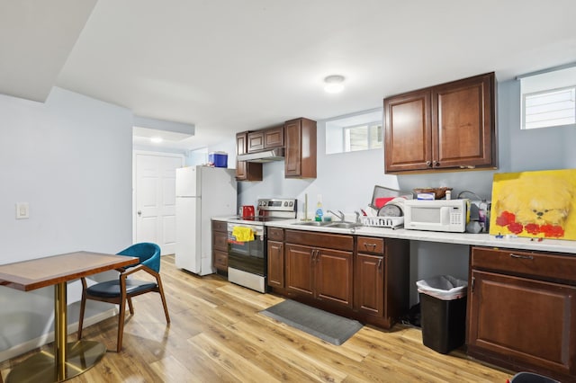 3532 Longfellow Ave, Minneapolis, MN 55407 - kitchen featuring white appliances, under cabinet range hood, a sink, light wood finished floors, and light countertops