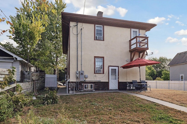 3532 Longfellow Ave, Minneapolis, MN 55407 - rear view of property with stucco siding, a balcony, and a chimney