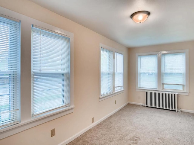 carpeted empty room with radiator heating unit