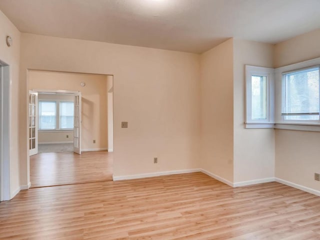 unfurnished room featuring light wood-type flooring and a healthy amount of sunlight