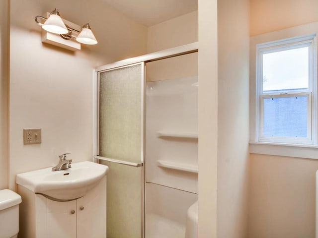 bathroom featuring vanity, toilet, and an enclosed shower