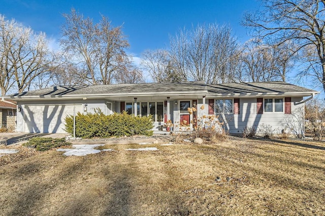 ranch-style home with a garage, covered porch, and a front lawn