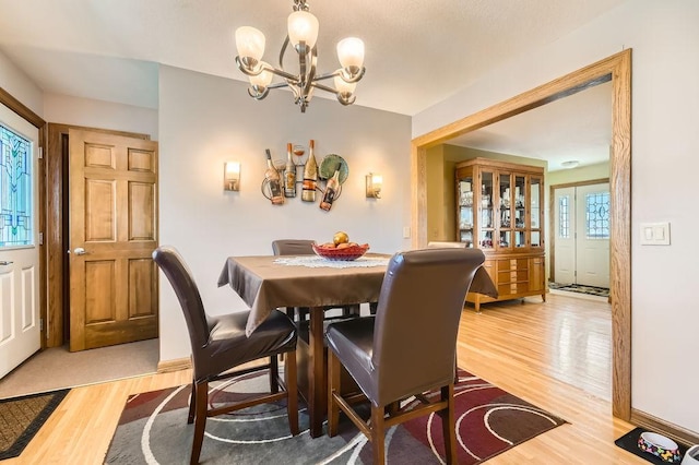 dining area featuring hardwood / wood-style floors and a notable chandelier