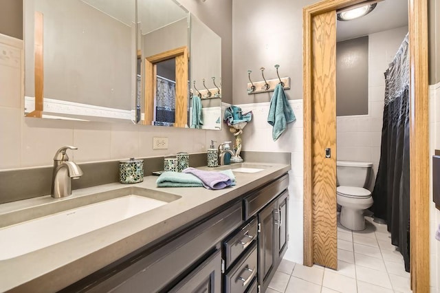 bathroom featuring tile walls, vanity, tile patterned flooring, and toilet