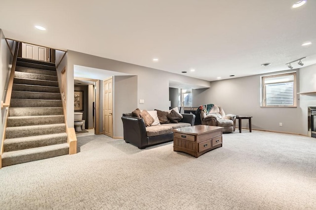 carpeted living room with track lighting