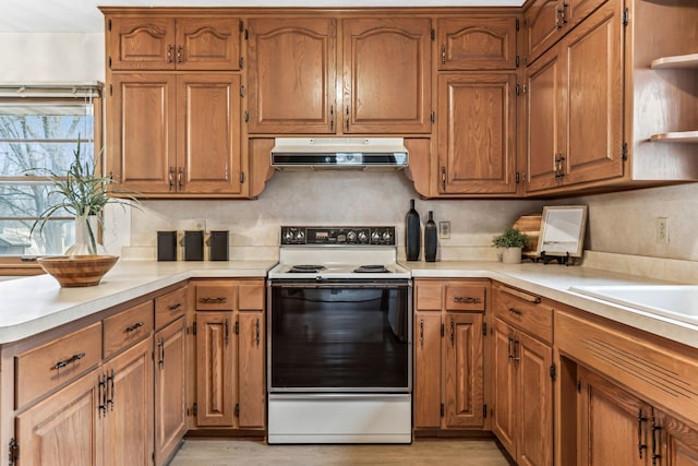 kitchen featuring light wood-type flooring, white range with electric stovetop, and backsplash