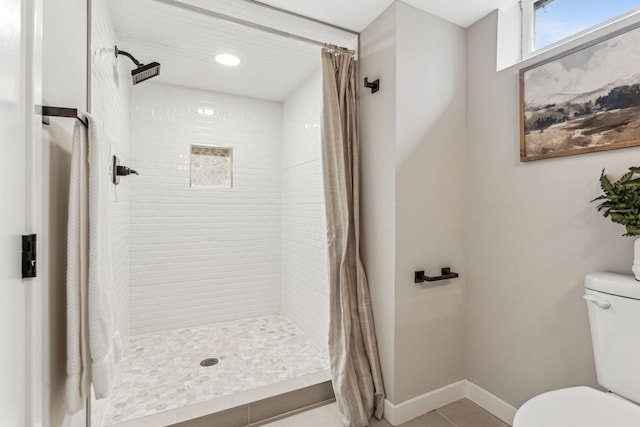 bathroom featuring a shower with curtain, toilet, and tile patterned floors