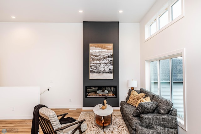 living area with a large fireplace and hardwood / wood-style flooring