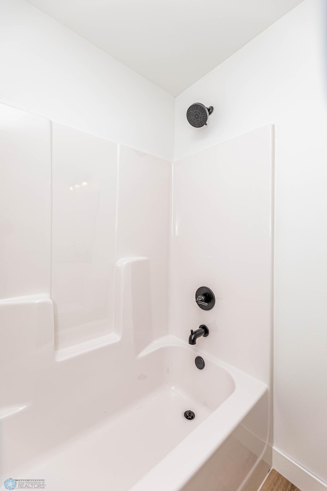 bathroom with hardwood / wood-style flooring and tub / shower combination