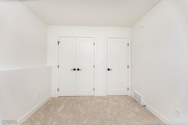 unfurnished bedroom with light colored carpet