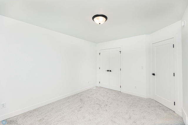 spare room featuring light colored carpet