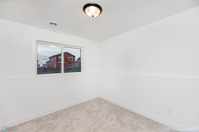 spare room featuring carpet and lofted ceiling