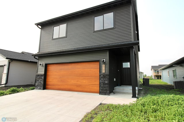 6721 67th Ave S, Horace, ND 58047 - contemporary house with stone siding, a garage, cooling unit, and driveway