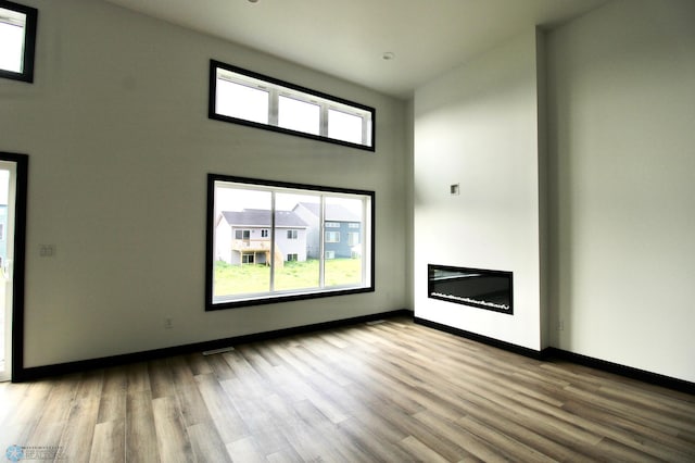 6721 67th Ave S, Horace, ND 58047 - unfurnished living room with wood finished floors, baseboards, and a glass covered fireplace
