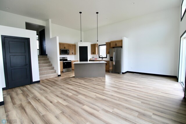 6721 67th Ave S, Horace, ND 58047 - kitchen featuring appliances with stainless steel finishes, a high ceiling, light countertops, a kitchen island, and light wood-style flooring