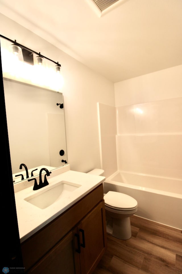 6721 67th Ave S, Horace, ND 58047 - bathroom featuring vanity, wood finished floors, toilet, and bathing tub / shower combination
