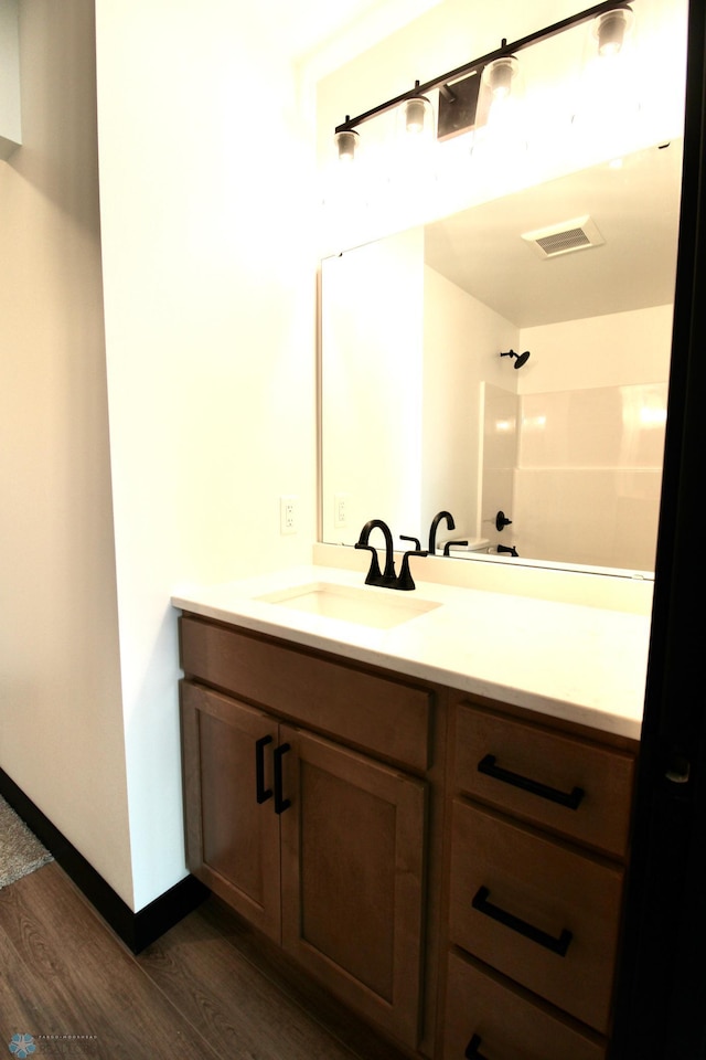 6721 67th Ave S, Horace, ND 58047 - bathroom with wood finished floors, vanity, a shower, and baseboards